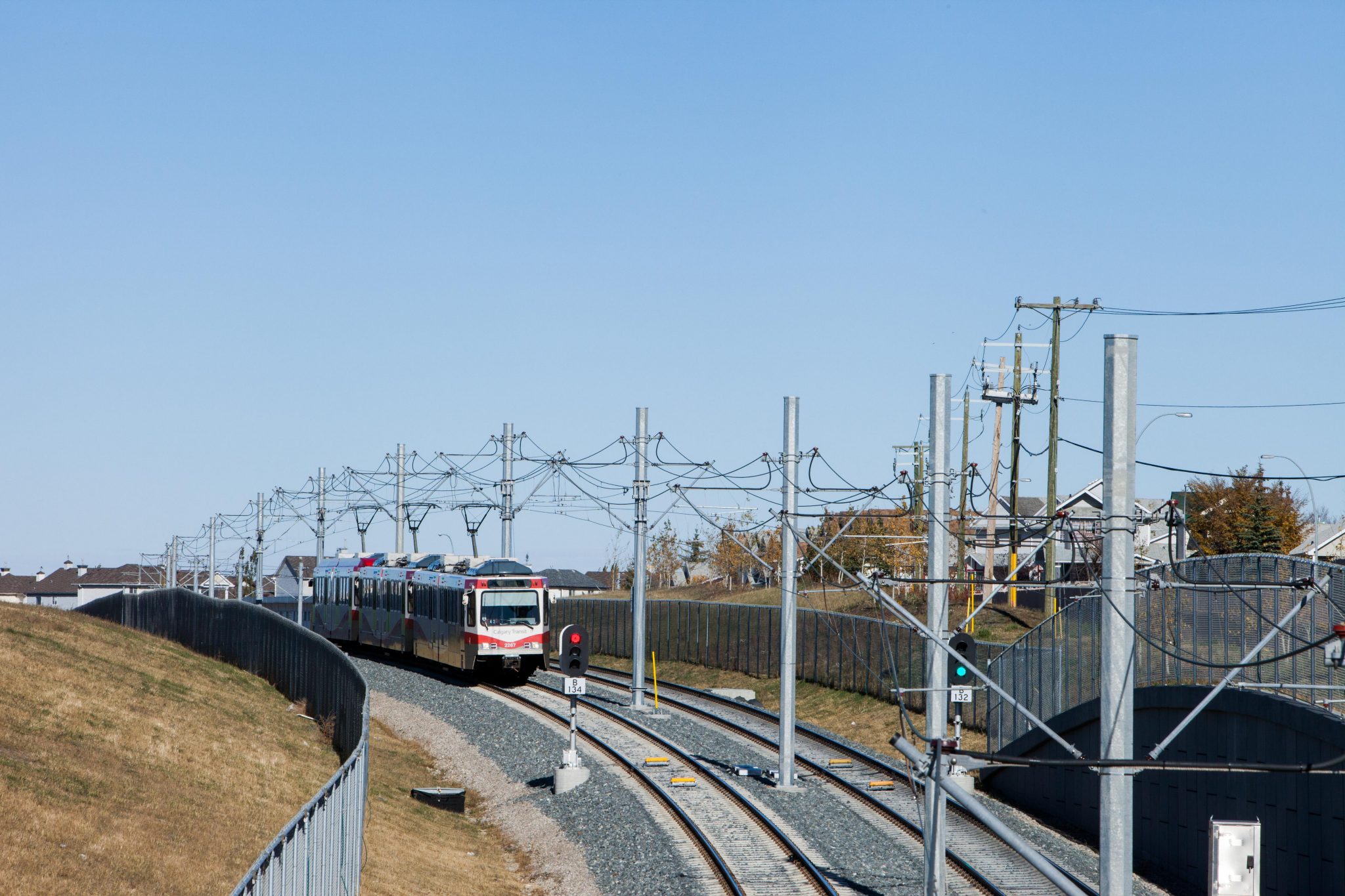 CTrain operates along the traction power system in Calgary under clear blue skies.